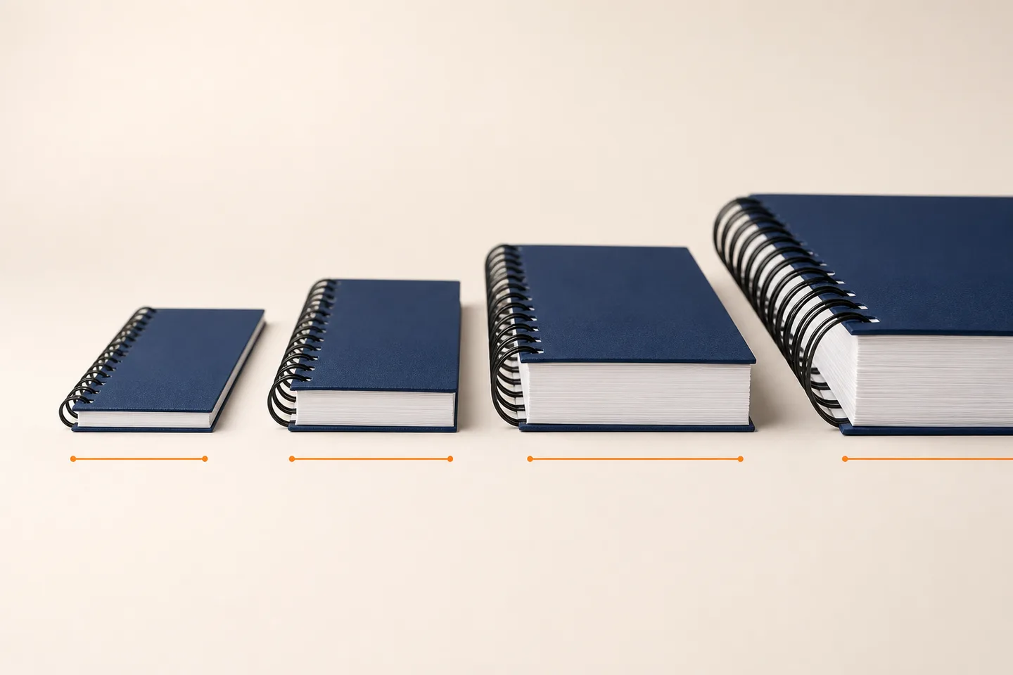 Cuatro cuadernos encuadernados con anillos negros de diámetro progresivo y bloques de papel cada vez más gruesos